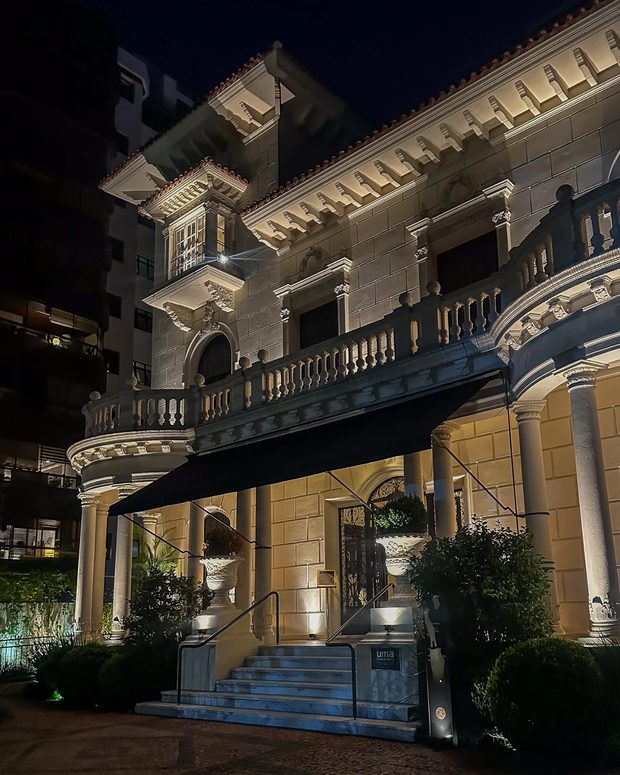 O casarão do Paço Santo Inácio à noite, iluminado, com a escadaria e o toldo da entrada.